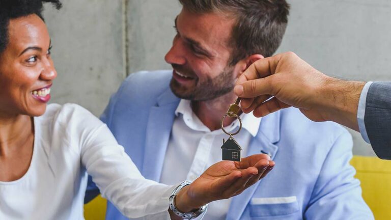 Realtor handing a couple the keys to their new home